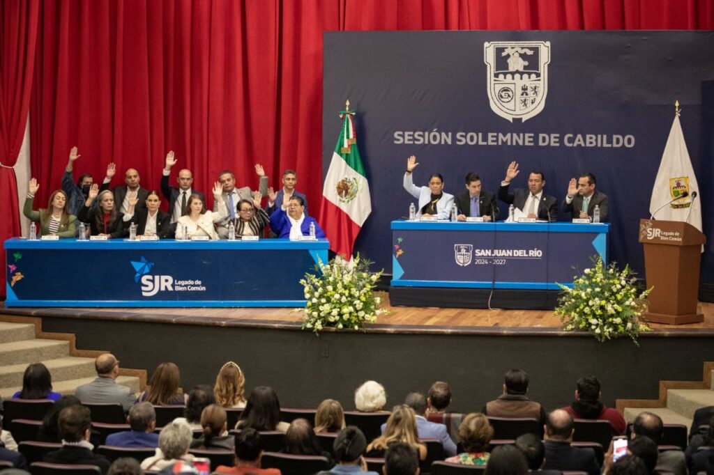 Cancelan sello postal conmemorativo de la fundación de San Juan del Río y reconocen a sanjuanenses distinguidos • Genoveva Sonia Butze Aguilar, impulsora del Museo Panteón de la Santa Vera Cruz, y el padre misionero xaveriano, Pablo Zurlo Zordonatzzo, recibieron la distinción. • El presidente municipal, Roberto Cabrera Valencia, se trasladó al Jardín Fundadores, donde montó una guardia de honor, acompañado de integrantes del Ayuntamiento y del Gabinete Municipal. San Juan del Río cumple 494 años y lo hace de pie, con dignidad y con rumbo, sostuvo el presidente municipal sanjuanense, Roberto Cabrera Valencia, en su mensaje con motivo de la sesión solemne de Cabildo, en la que se llevó a cabo la cancelación especial del sello postal conmemorativo de la fundación de la ciudad y la entrega de reconocimientos a sanjuanenses distinguidos. Durante la sesión, realizada en el Foro San Juan del Portal del Diezmo, Roberto Cabrera agradeció a quienes aman y cuidan a San Juan del Río; a quienes sueñan en grande y trabajan con humildad; a quienes saben que la historia se honra con palabras y obras. Recordó que San Juan del Río se prepara para cumplir medio siglo, con la frente en alto y con el corazón dispuesto, pues, enfatizó, la mejor manera de honrar el pasado es cumplirle al presente y sembrar progreso en el futuro. “Hoy, como cada 24 de junio, nos reúne la memoria de un pueblo que nació a orillas de un río generoso, que con su cauce marcó el destino de generaciones enteras. San Juan del Río cumple hoy 494 años de fundación, y lo celebramos con orgullo, con gratitud y con profunda responsabilidad. Esta sesión solemne de Cabildo tiene un significado especial. Porque no sólo estamos conmemorando una fecha: Estamos reconociendo un legado. Un legado que nos compromete. Un legado que tiene nombre y sentido: el Legado de Bien Común”, dijo Cabrera Valencia. Tras la lectura de la reseña histórica de la fundación de San Juan del Río, a cargo de la síndica del Ayuntamiento, Rosalba Ruiz Ramos, el presidente municipal sanjuanense, Roberto Cabrera Valencia, acompañado de la Reina de la Feria Nacional Ganadera San Juan del Río 2025, Hanney I, y el gerente estatal de Correos de México en Querétaro, Juan Manuel Contreras Espinoza, realizaron la cancelación especial del sello postal. Posteriormente, el alcalde de San Juan del Río entregó un reconocimiento como sanjuanense distinguida a Genoveva Sonia Butze Aguilar, investigadora del Instituto Nacional de Antropología e Historia (INAH) e impulsora del Museo Panteón de la Santa Vera Cruz (antes Museo de la Muerte), además de conservadora del patrimonio, tradiciones y educación, entre otras actividades relacionadas con la actividad museográfica. El padre misionero xaveriano, Pablo Zurlo Zordonatzzo, de manera póstuma, también fue distinguido con el reconocimiento de sanjuanense distinguido. En representación del galardonado, el misionero xaveriano y superior del Seminario de San Juan del Río, Samuel Godínez Uribe, recibió la distinción de Pablo Zurlo, quien se caracterizó por el desarrollo de las personas de este municipio. En la sesión solemne de Cabildo estuvieron presentes las y los integrantes del Ayuntamiento de San Juan del Río, miembros del Gabinete Municipal, familiares de los y las galardonadas, entre otras personalidades, quienes, en conjunto con el presidente municipal, Roberto Cabrera Valencia, se trasladaron al Jardín Fundadores, donde montaron una guardia de honor, y a la Parroquia de San Juan Bautista.