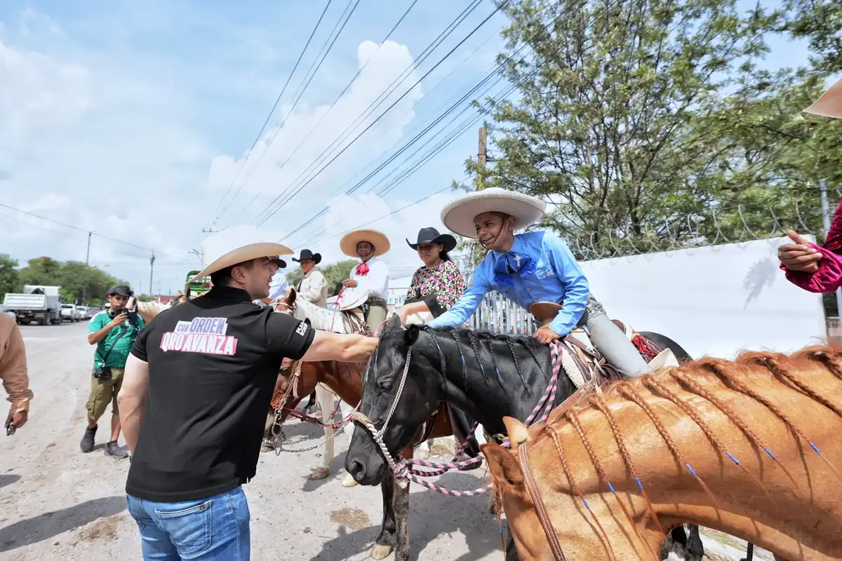 Felifer Macías saluda a participante durante cabalgata en Santa Rosa Jáuregui